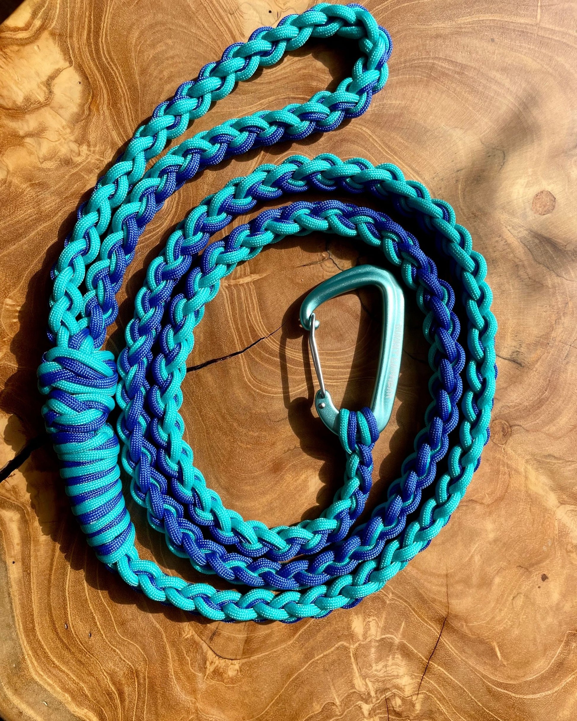 Coiled Bobby leash with blue and teal paracord and a teal carabiner clip. Named after Cascade Falls